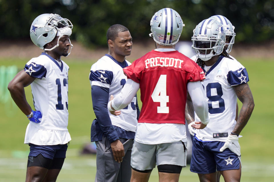 Dallas Cowboys quarterback Dak Prescott (4) speaks with wide receivers Michael Gallup (13), Amari Cooper (19) and CeeDee Lamb (88) during an NFL football team practice Tuesday, June 8, 2021, in Frisco, Texas. (AP Photo/LM Otero)