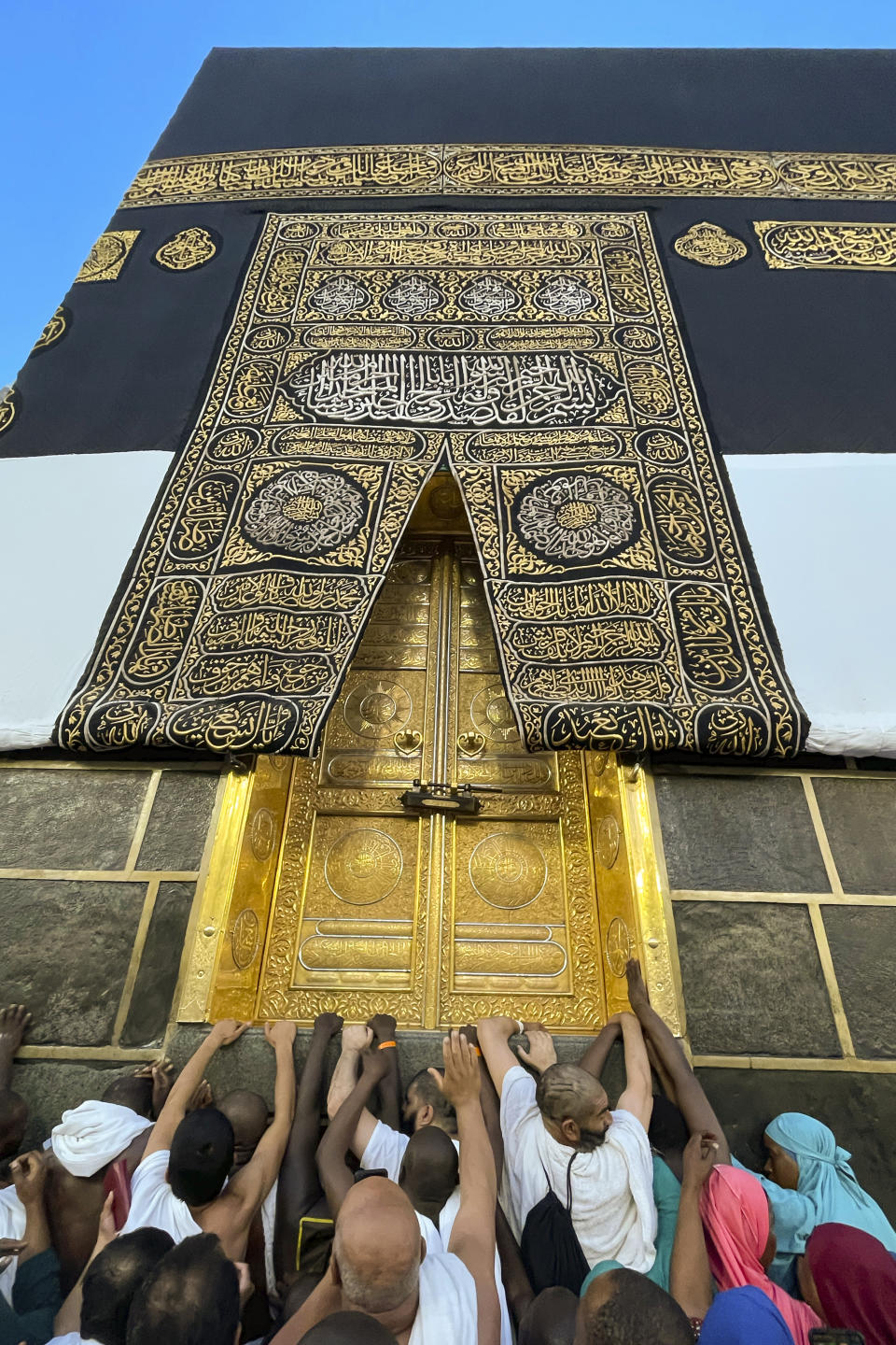 Muslim pilgrims pray in front of the Kaaba door, the cubic building at the Grand Mosque, during the annual hajj pilgrimage in Mecca, Saudi Arabia, Monday, June 26, 2023, before heading to Mina in preparation for the Hajj, the fifth pillar of Islam and one of the largest religious gatherings in the world. (AP Photo/Amr Nabil)