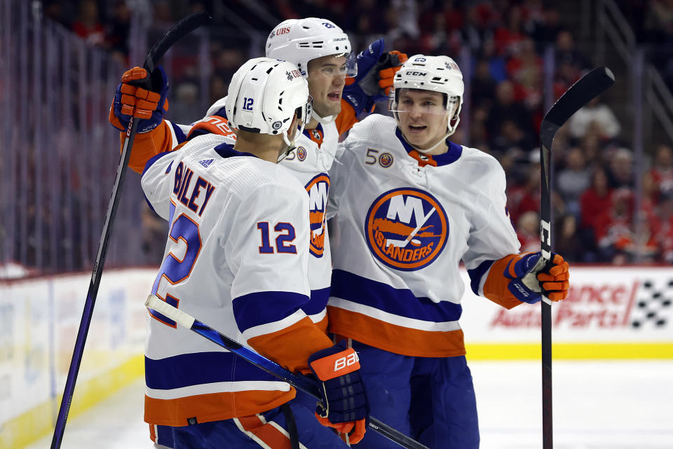 New York Islanders' Oliver Wahlstrom (26) is congratulated on his goal by teammates Josh Bailey (12) and Sebastian Aho (25) during the first period of an NHL hockey game against the Carolina Hurricanes in Raleigh, N.C., Friday, Oct. 28, 2022. (AP Photo/Karl B DeBlaker)