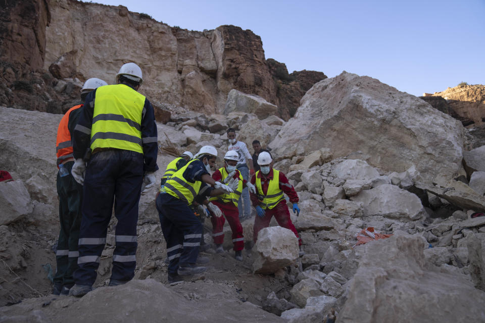 Rescue workers remove rocks as they look for survivors in a buried house, in the town of Imi N'tala, outside Marrakech, Morocco, Wednesday, Sept. 13, 2023. An aftershock rattled central Morocco on Wednesday, striking fear into rescue crews at work in High Atlas villages, digging people out from rubble that could slide. (AP Photo/Mosa'ab Elshamy)