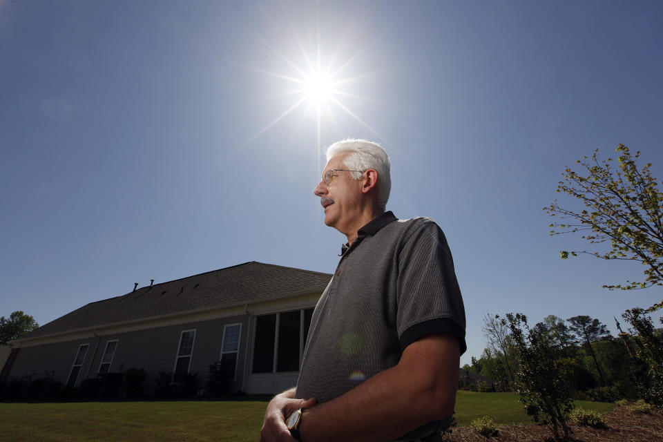 David Dobs poses in front of his home in Cumming, Ga., Monday, April 9, 2012. Dobs' home owners' association denied his request to install solar panels on his roof. Georgia lawmakers narrowly defeated a bill this year that would have prevented homeowners associations from banning solar panels. (AP Photo/John Bazemore)