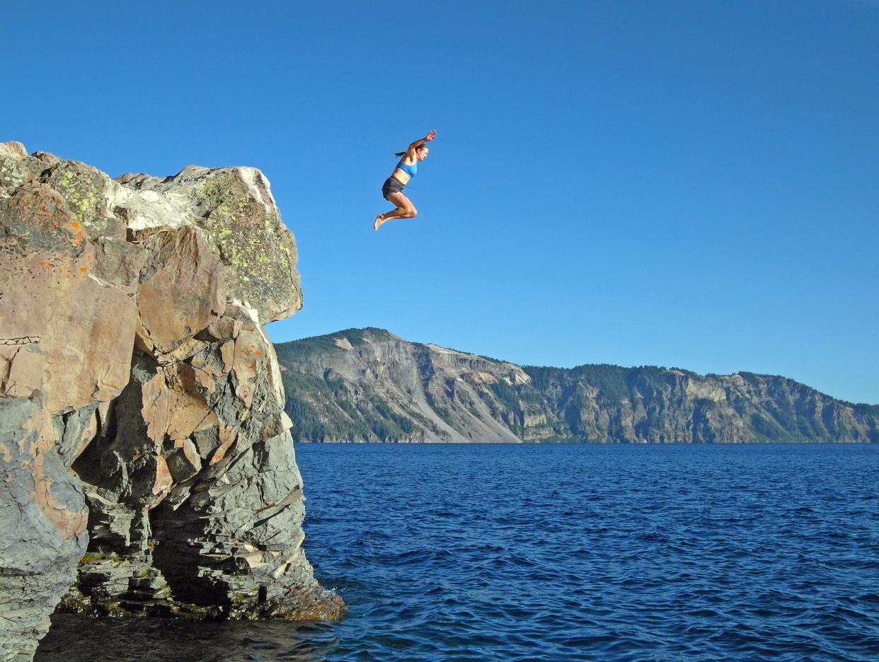 A swimmer jumps off a rock near Cleetwood Cove Trail.