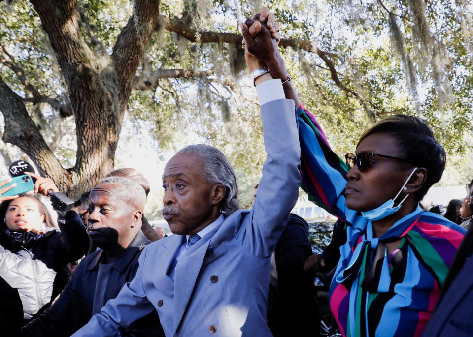 The Rev. Al Sharpton and Wanda Cooper-Jones, mother of Ahmaud Arbery, raise their hands outside the Glynn County Courthouse on Wednesday after the jury reached the verdict. Arbery's father, Marcus, is at Sharpton's left.