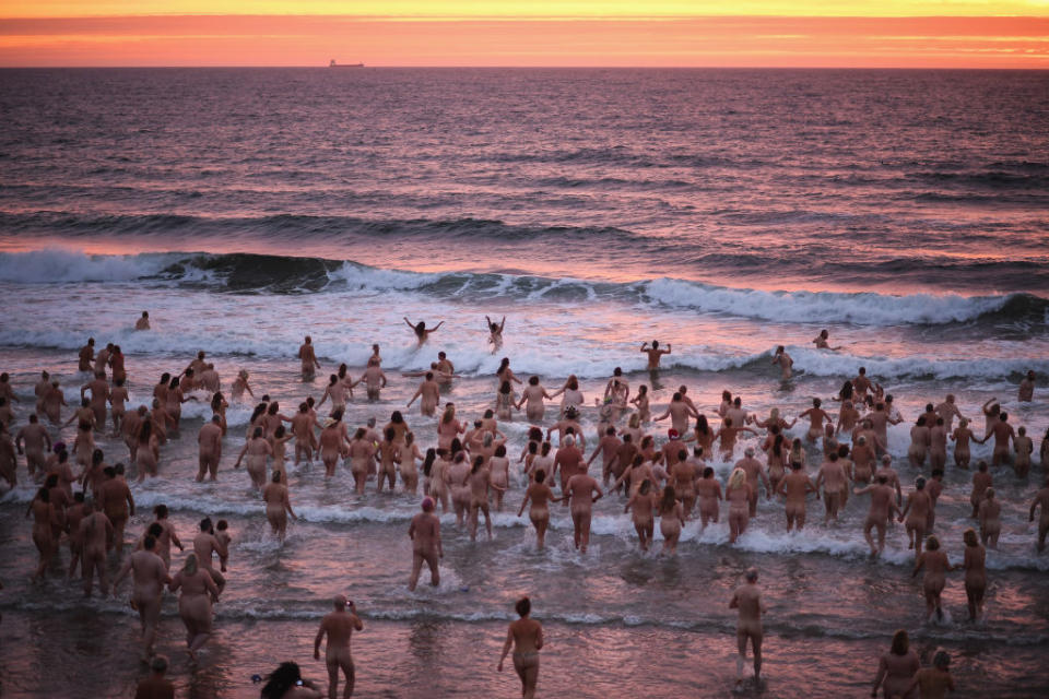 <p>Naked bathers enter the water as they take part in the North East Skinny Dip at Druridge bay in Druridge, England. The popular annual event takes place around the autumn equinox as the sun rises. Participant registration fees have been pledged to the mental health charity MIND. (Jeff J Mitchell/Getty Images) </p>