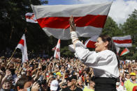 FILE In this file photo taken on Sunday, Aug. 2, 2020, Sviatlana Tsikhanouskaya, candidate for the presidential elections greets people waving old Belarus flags during a meeting to show her support, in Brest, 326 km (203,7 miles) southwest of Minsk, Belarus. Previously apolitical, Kseniya Milya was among those who flocked to campaign rallies of Sviatlana Tsikhanouskaya, a 37-year old ex-teacher and wife of a jailed opposition blogger, who is challenging Lukashenko in Sunday's vote. (AP Photo/Sergei Grits, File)