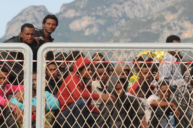 Migrants wait to disembark from the military ship "Bettica" following a rescue operation at sea on May 5, 2015 in the port of Salerno, southern Italy