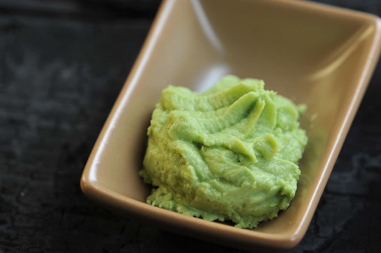 Wasabi is a seasoning of Japanese cuisine. Wasabi in a ceramic bowl.