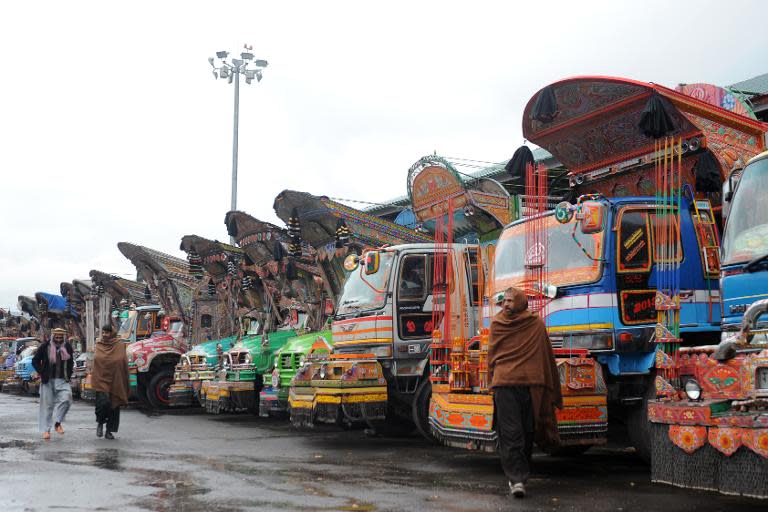 Stranded truck drivers from Pakistan-administered Kashmir walk past their parked trucks at the Trade Facilitation Centre at Salambad in Uri, some 115 kilometres from Srinagar, on January 21, 2014