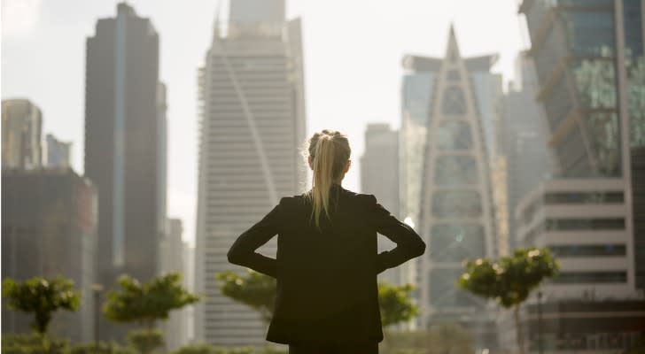 A real estate investor looks out over a city skyline. 