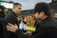 Oregon head coach Mario Cristobal, left, and Oregon State head coach Jonathan Smith shake hands after an NCAA college football game Saturday, Nov. 27, 2021, in Eugene, Ore. (AP Photo/Andy Nelson)