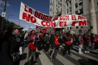 Demonstrators hold a banner that reads "The debt is with the people not the FMI" during a protest against the government’s economic measures in Buenos Aires