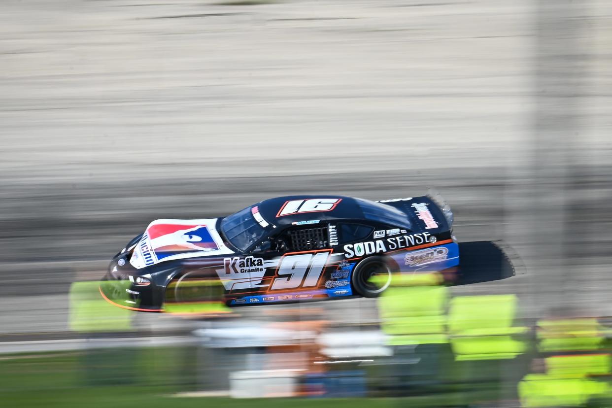 Ty Majeski flashes past a group of photographers in between Turns 3 and 4 in the ASA Midwest Tour opener on Sunday.