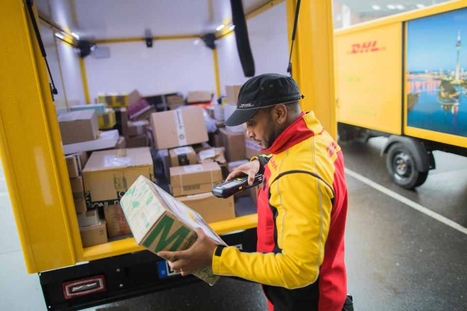 Ein Paketbote scannt mit seinem mobilen Gerät ein Paket. (Bild: dpa)