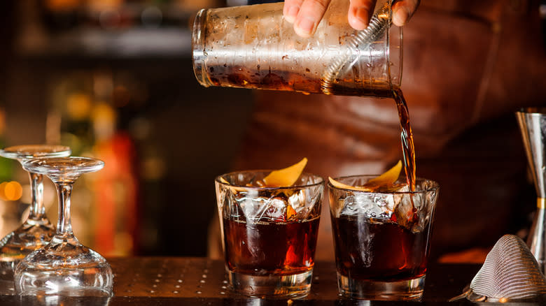 Hand pouring two cocktails