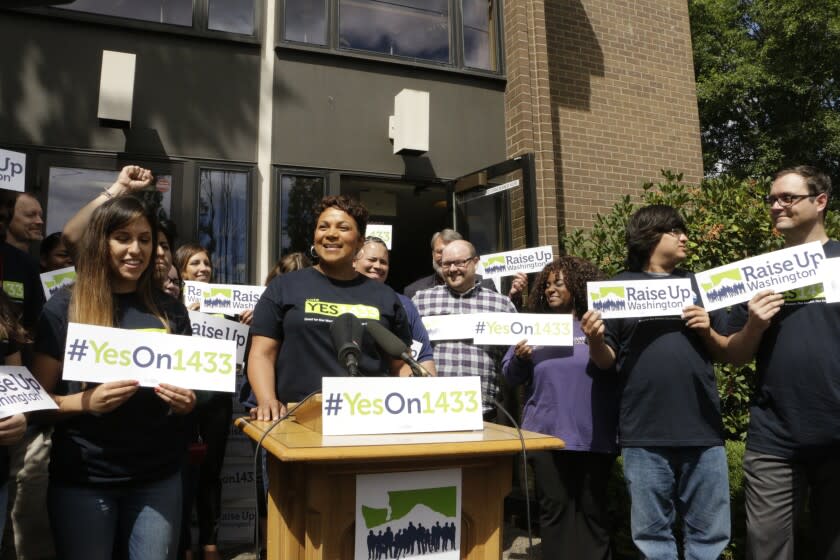 Supporters gather to talk to the media before turning in signed petitions in support of a ballot measure to raise Washington state's minimum wage, on Wednesday, July 6, 2016, in Olympia, Wash. Initiative 1433 seeks to incrementally increase the state's rate over the next four years to $13.50 an hour and to provide paid sick leave to employees who don't currently have it. (AP Photo/Rachel La Corte)