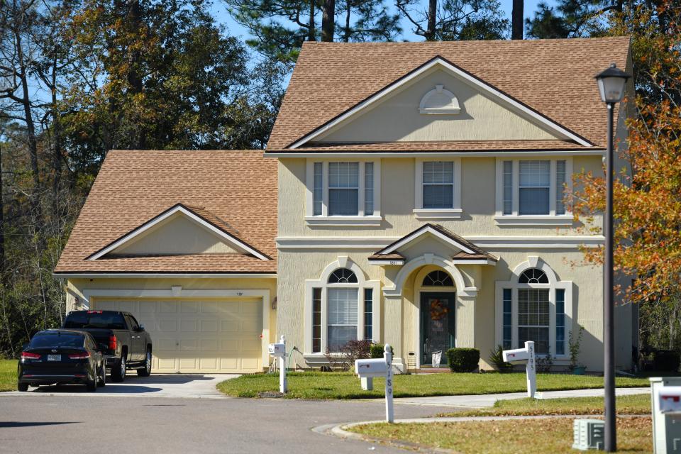 A couple of vehicles remain at 5201 Johnson Lake Court on Tuesday where Otis Anderson Jr. was shot and killed the night before and his mother wounded. Anderson's father was arrested by Jacksonville police.