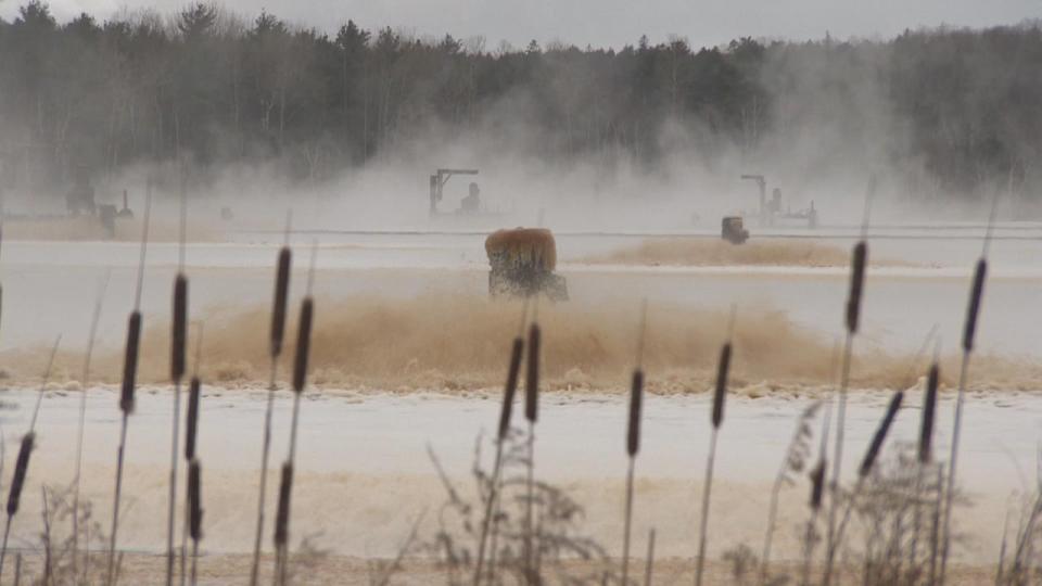 Aerators churn up toxic mill waste in what is now lifeless, dark and foamy Boat Harbour.