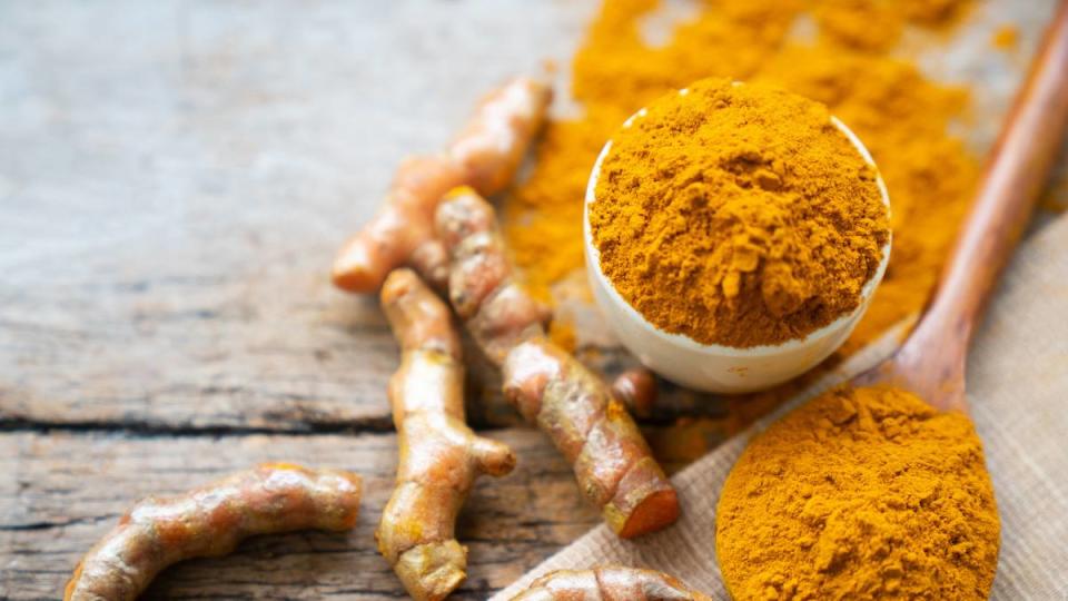 Turmeric powder and fresh turmeric on wooden  table