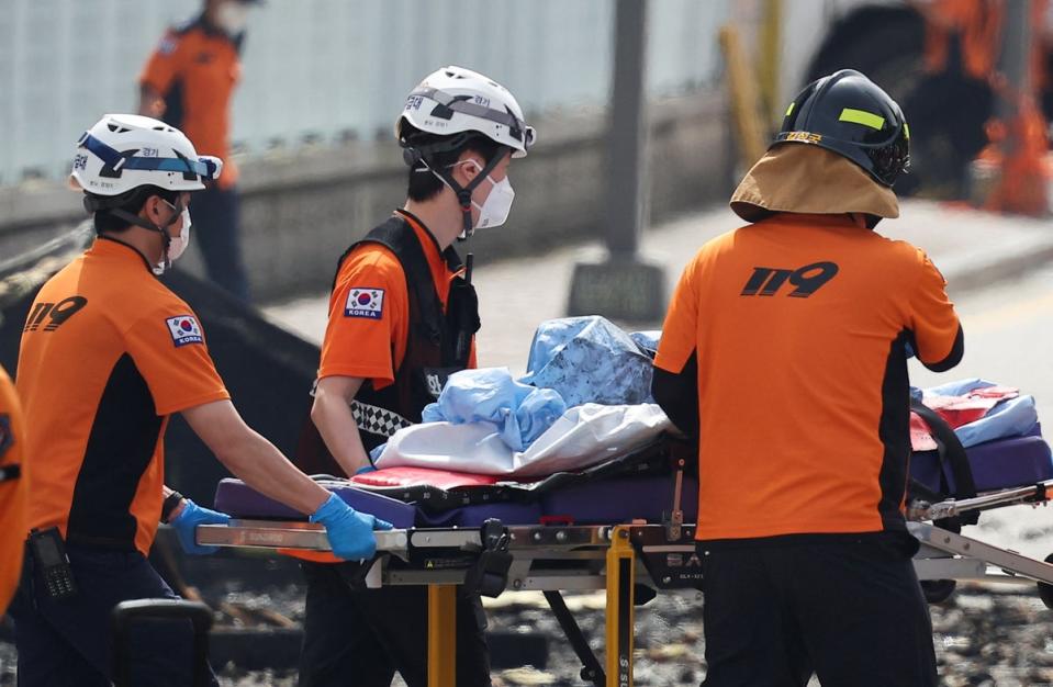 Emergency personnel carry the body of a person killed in a deadly fire at a lithium battery factory owned by South Korean battery maker Aricell (REUTERS)