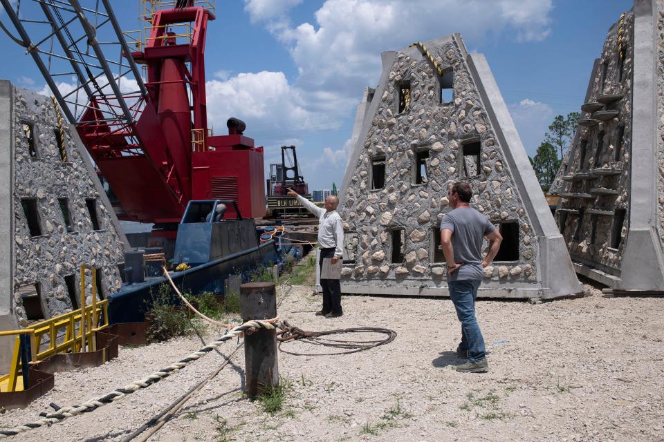 Escambia County Marine Resources Manager Robert Turpin inspects newly cast Florida limestone artificial reefs for defects with Walter Marine owner Stewart Walter on Friday, June 2, 2023. The eight-foot-tall 5,500-pound structures built by Walter Marine are set to be deployed in the Gulf of Mexico of Pensacola Beach in early summer.