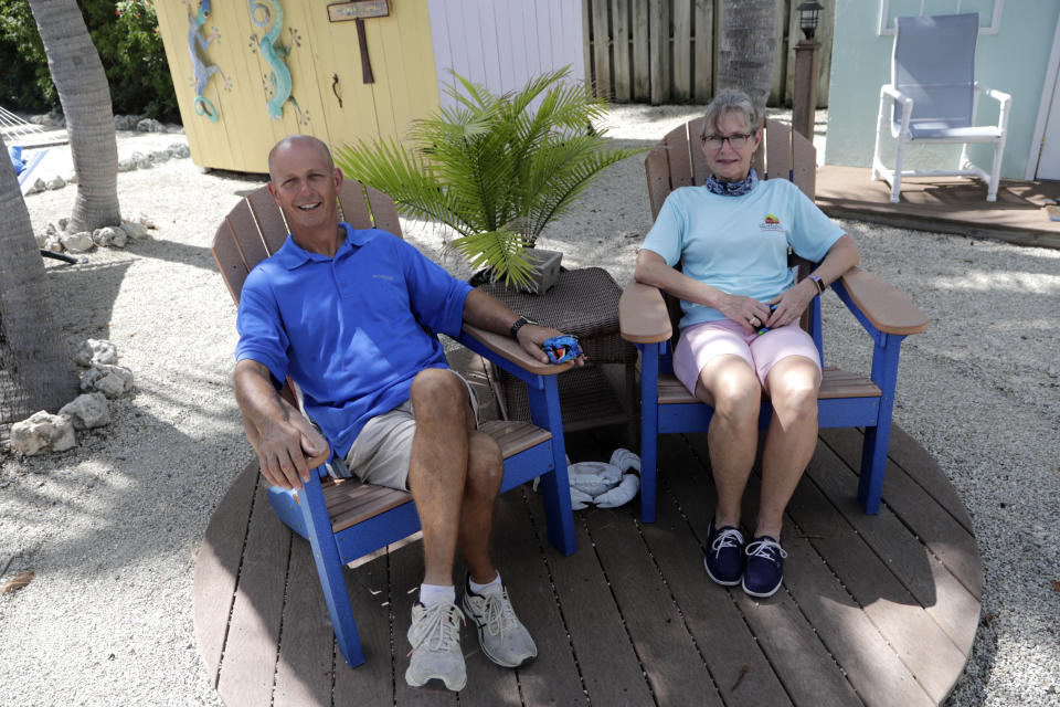 Mike and Carol Shipley, owners of the Island Bay Resort, pose for a photograph at the resort in Tavernier, in the Florida Keys, during the new coronavirus pandemic, Monday, June 1, 2020. Their resort is open for guests as the Florida Keys reopened for visitors Monday after the tourist-dependent island chain was closed for more than two months to prevent the spread of the coronavirus. (AP Photo/Lynne Sladky)