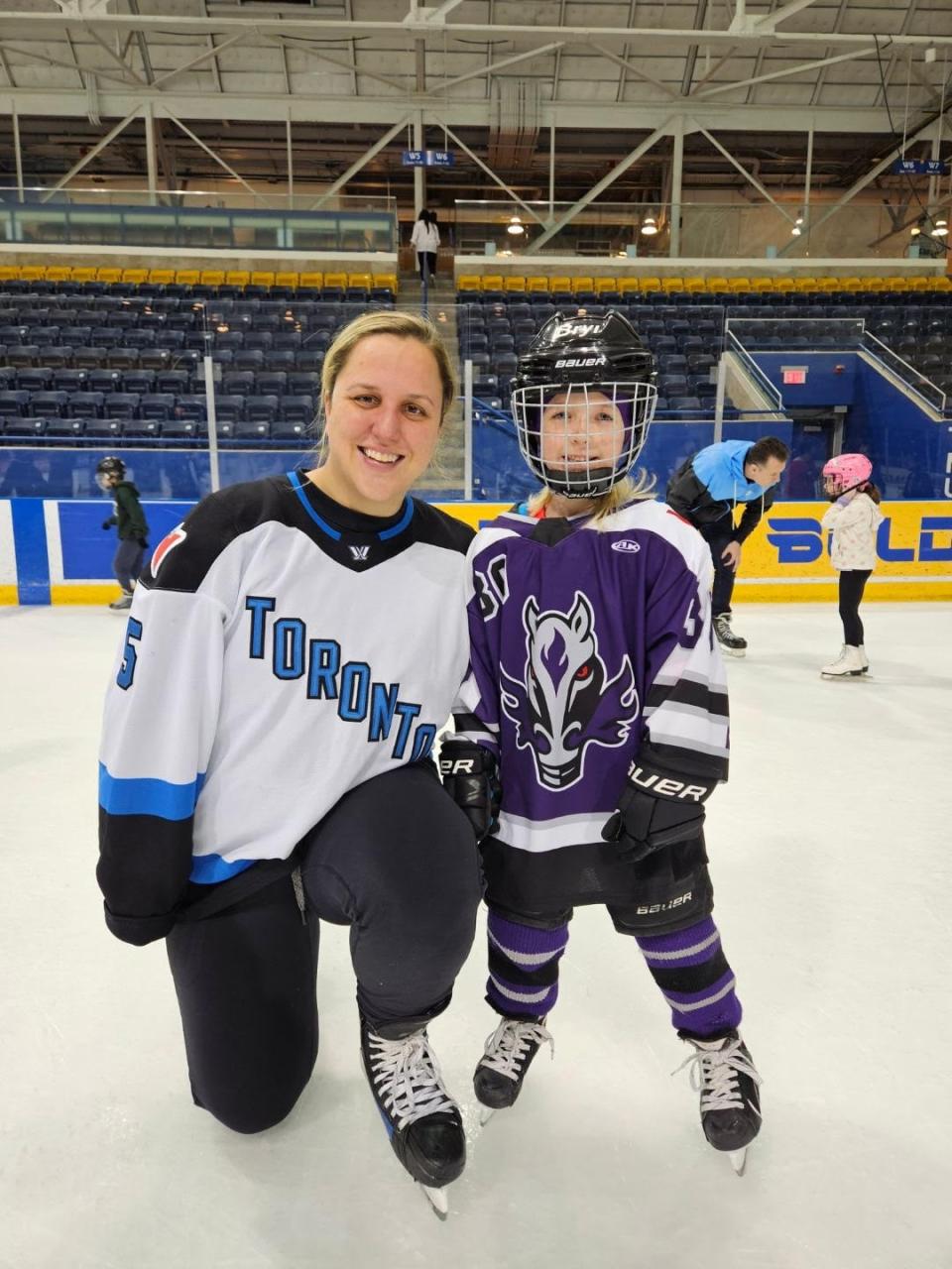 A Grand River Mustangs player posing with a Toronto player from the PWHL.