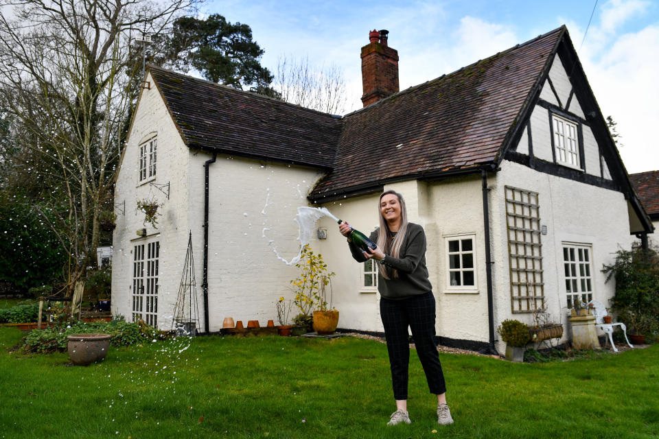 Jemma Nicklin, 23, celebrates with a bottle of champagne during her first visit to Shrubbery Farm in Longnor near Shrewsbury, a 300-year-old four bedroom farmhouse which she won after buying two £2 tickets in a raffle organised by owner Mike Chatha. Photo: Jacob King/PA via Getty Images