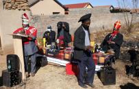 A congregant holds a glass of beer as "Pope" Tsietsi Makiti conducts a service at the Gabula church