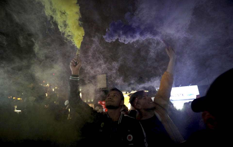 Men set off flares during a "Kiss-a-thon" held as a form of protest for LGBT rights in Bogota, Colombia, Wednesday, April 17, 2019. The event was held at the same Andino shopping mall where days ago two gay men were harassed by a customer who lured police into fining them for "exhibitionism." (AP Photo/Fernando Vergara)