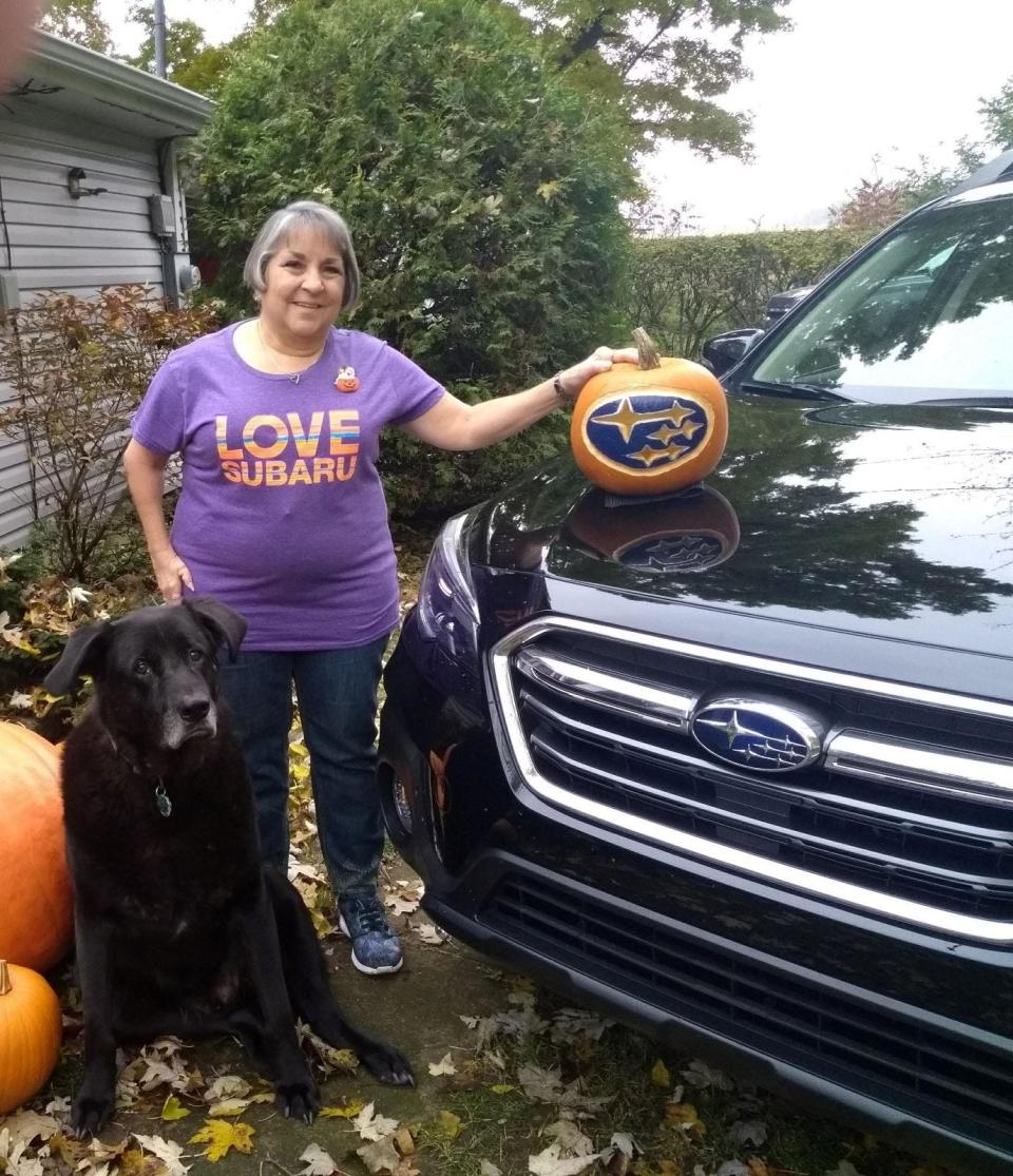 Shelly Baldwin, along with her late pet, Black Jack, with one of the Subaru Outbacks she's owned. Baldwin is a big Subaru fan and is a member of Moo Moo Subaru.