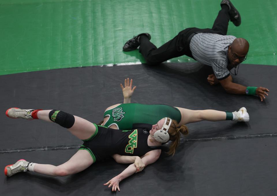 Chloe Dearwester, top, of Harrison, wrestling in the finals of the 105-pound weight class, is about to pin Scotlyn Adams of West Union, thus winning the match in the OHSAA regional girls wrestling tournament at Harrison High School March 5, 2023. The top four girls in each weight class advance to the state tournament in Columbus, Ohio.