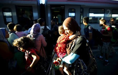 Travellers believed to be migrants coming from Hungary enter a train to Germany at the railway station in Vienna, Austria, August 31, 2015. REUTERS/Leonhard Foeger