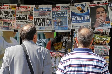 People look at newspapers showing the results of yesterday's referendum in central Athens, Greece, July 6, 2015. REUTERS/Jean-Paul Pelissier