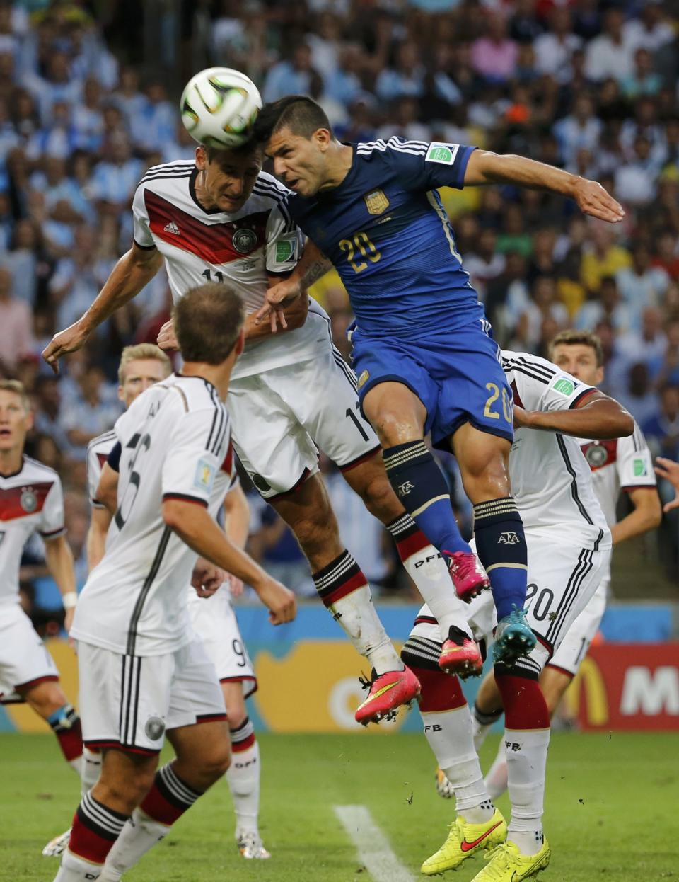 Germany's Miroslav Klose jumps for the ball with Argentina's Sergio Aguero during their 2014 World Cup final at the Maracana stadium in Rio de Janeiro July 13, 2014. REUTERS/Sergio Moraes (BRAZIL - Tags: SOCCER SPORT WORLD CUP TPX IMAGES OF THE DAY)