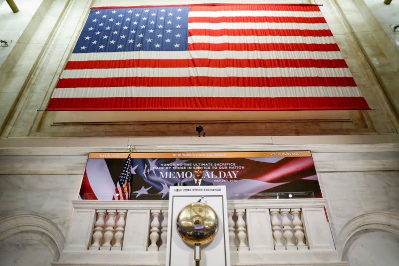 FILE PHOTO: A staff member rings closing bell in honor of Memorial Day and the lives lost in military service to the U.S., as preparations are made for the return to trading, on the floor at the NYSE in New York