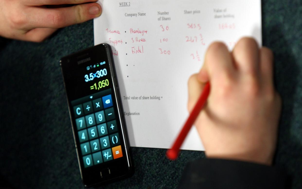 A child using a smartphone calculator in maths class - PA