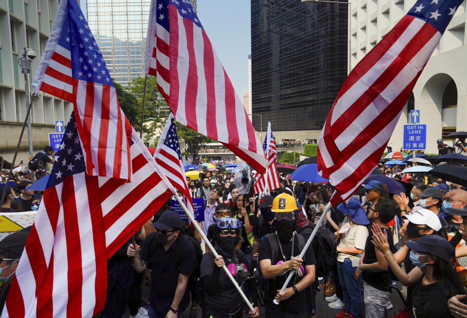 Protesters shout slogans and wave U.S. flags as they march from Chater Garden to the U.S. Consulate in Hong Kong, Sunday, Sept. 8, 2019. Demonstrators in Hong Kong plan to march to the U.S. Consulate on Sunday to drum up international support for their protest movement, a day after attempts to disrupt transportation to the airport were thwarted by police. (AP Photo/Vincent Yu)