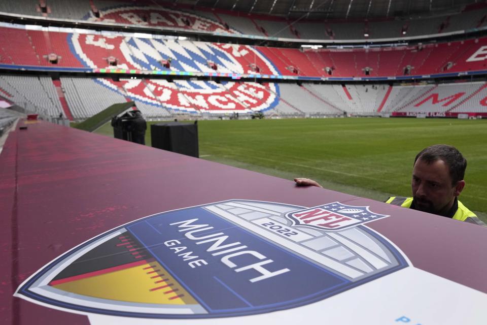 Workers prepare a sign inside the FC Bayern Munich soccer stadium Allianz Arena in Munich, Germany, Wednesday, Nov. 9, 2022. The Tampa Bay Buccaneers are set to play the Seattle Seahawks in an NFL game at the Allianz Arena in Munich on Sunday. (AP Photo/Matthias Schrader)