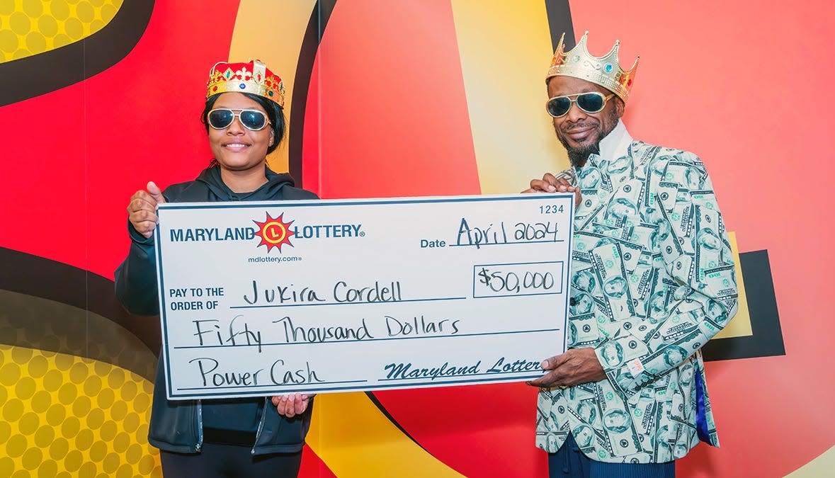 Jukira Cordell (left), of Pocomoke City, and her friend, Eric Jones, pose with a mock check for her recent $50,000 Maryland Lottery prize from playing the Power Cash scratch-off game. The pair, according to the Lottery, felt like royalty.