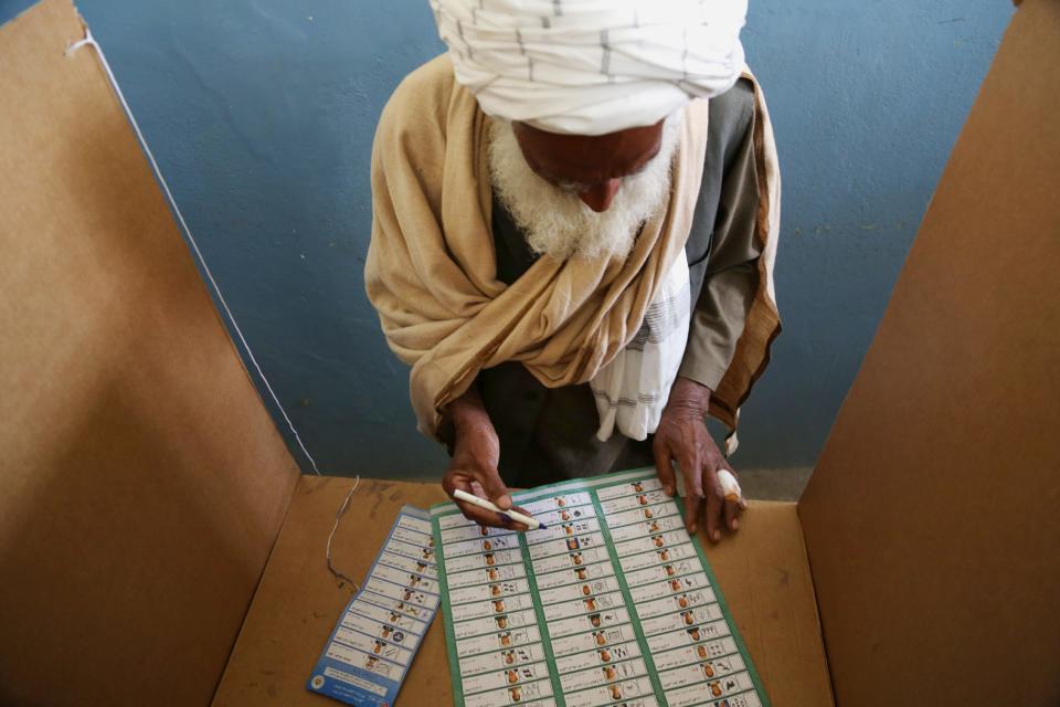 An Afghan man fills his ballot at a polling station in Jalalabad, east of Kabul, Afghanistan, Saturday, April 5, 2014. Afghan voters lined up for blocks at polling stations nationwide on Saturday, defying a threat of violence by the Taliban to cast ballots in what promises to be the nation's first democratic transfer of power. The vote will decide who will replace President Hamid Karzai, who is barred constitutionally from seeking a third term. (AP Photo/Rahmat Gul)