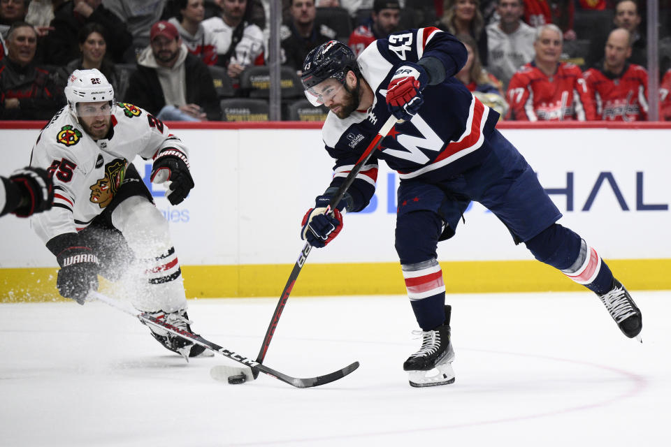 Washington Capitals right wing Tom Wilson (43) shoots against Chicago Blackhawks defenseman Jarred Tinordi (25) during the first period of an NHL hockey game, Saturday, March 9, 2024, in Washington. (AP Photo/Nick Wass)