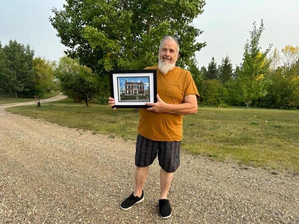Bob Walde of Neilburg, Saskatchewan, Canada holds a picture of the Dr. Isaac Fiske House. Walde is a distant relative of Fiske, a Fall River doctor who harbored fugitives fleeing slavery in the 1860s.