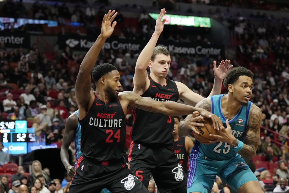 Charlotte Hornets forward P.J. Washington goes to the basket as Miami Heat forward Haywood Highsmith (24) and forward Nikola Jovic defend during the second half of an NBA basketball game, Sunday, Jan. 14, 2024, in Miami. (AP Photo/Lynne Sladky)