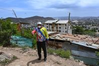 <p>El camino de Yulimar para ser la reina de las pistas no ha sido fácil.</p> <p>Como muchos otros venezolanos, creció en una barriada pobre de Anzoátegui, un estado de la costa oriental que fue un importante eje turístico y petrolero del país. La imagen muestra Pedro Zapata, el padrastro de la atleta, justo en el lugar donde vivía la familia de seis hijos. Zapata contó que el "ranchito", como se le dice en Venezuela a las viviendas precarias que construyen las personas de bajos recursos con sus propias manos, ya no existe porque fue arrazado por el agua y el viento de una tormenta.</p> <p>Yulimar atribuye a Zapata el mérito de haberle inculcado el amor por el deporte. Se considera su "fan número uno" por su desempeño como boxeador y por haberla ayudado a crecer en un ambiente deportivo.</p> <p>(Photo by YURI CORTEZ/AFP via Getty Images).</p> 