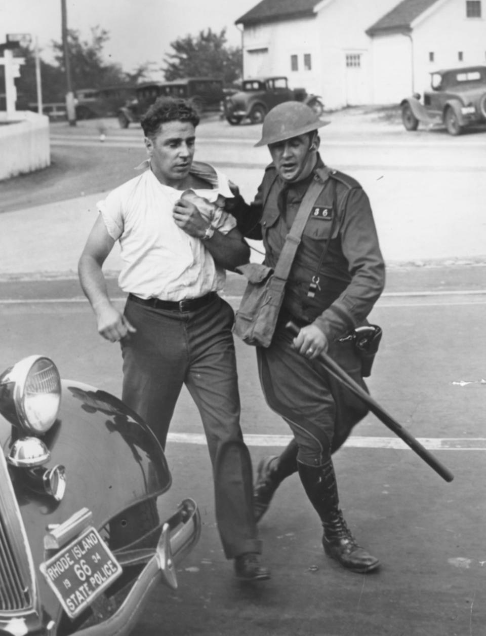 A state police officer drags off a picketing worker outside Lincoln's Saylesville mill in the 1930s. State police and militia units were called in to quell a four-hour riot.