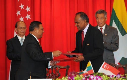 Myanmar President Thein Sein (L) and Singapore Prime Minister Lee Hsien Loong (R) witness the exchange of a memorandum of understanding (MOU) by Singapore Minister Foreign K. Shanmugam (2nd R) and Myanmar's Union Minister for Foreign Affairs U Wunna Maung Lwin at the presidential palace in Singapore