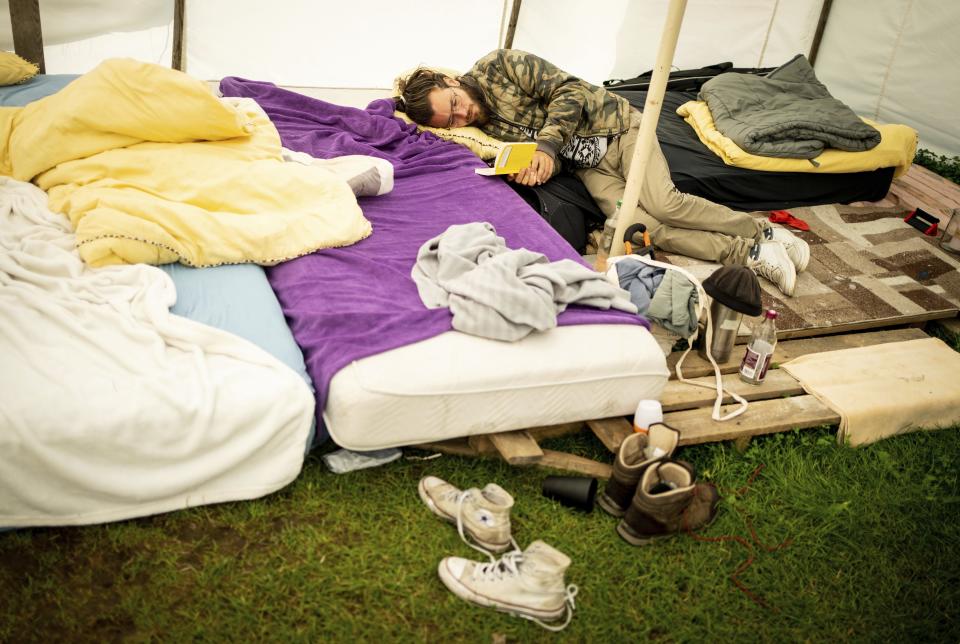 FILE - In this Sept. 15, 2021 file photo, Jakob lies in the morning on a mattress camp in a tent of a protest camp in the government district. in Berlin, Germany. The activist has been on hunger strike for climate protection. The German government on Monday urged a group of young climate activists staging a hunger strike outside the chancellery not to endanger their health. Several of the activists have threatened to stop consuming liquids, too, unless the three leading candidates to succeed Angela Merkel as chancellor agree to meet them by Thursday evening. (Kay Nietfeld/dpa via AP, File)