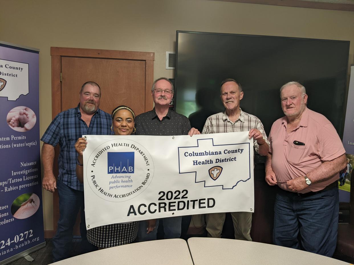 Members of the Columbiana County Board of Health show off a sign that depicts the agency's national accreditation.