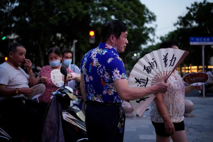 Imagen de archivo de varias personas abanicándose en medio de la ola de calor en Shanghái, China.