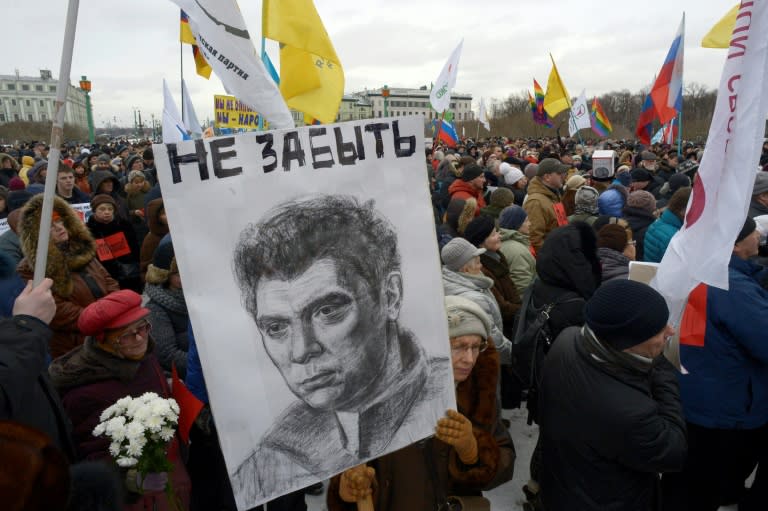 A woman holds a portrait of murdered opposition leader Boris Nemtsov during a memorial march in February